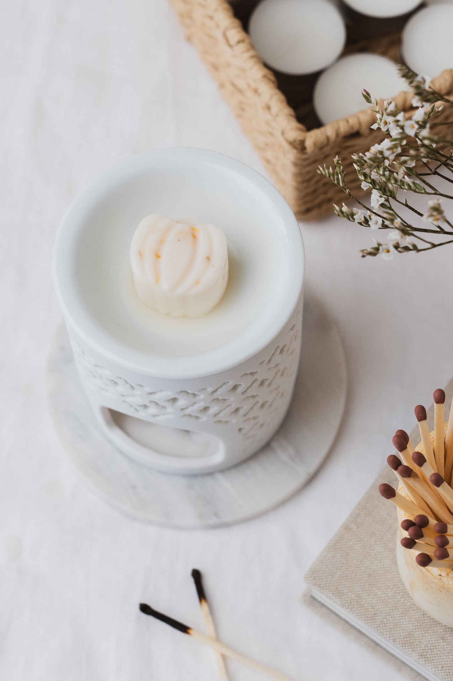 A pumpkin-shaped wax melt in a wax burner.