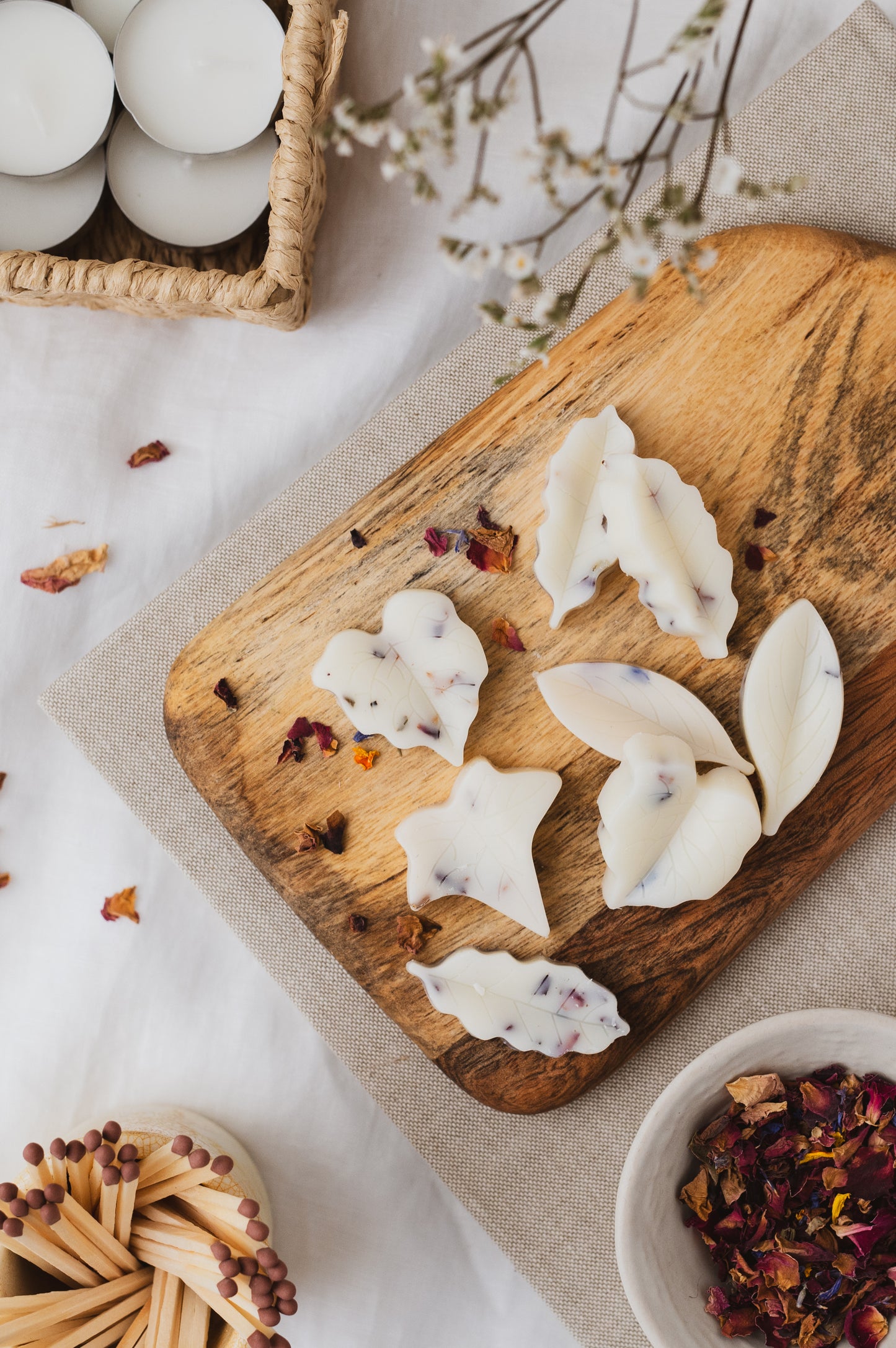 Leaf-shaped botanical soy wax melts displayed on a chopping board.