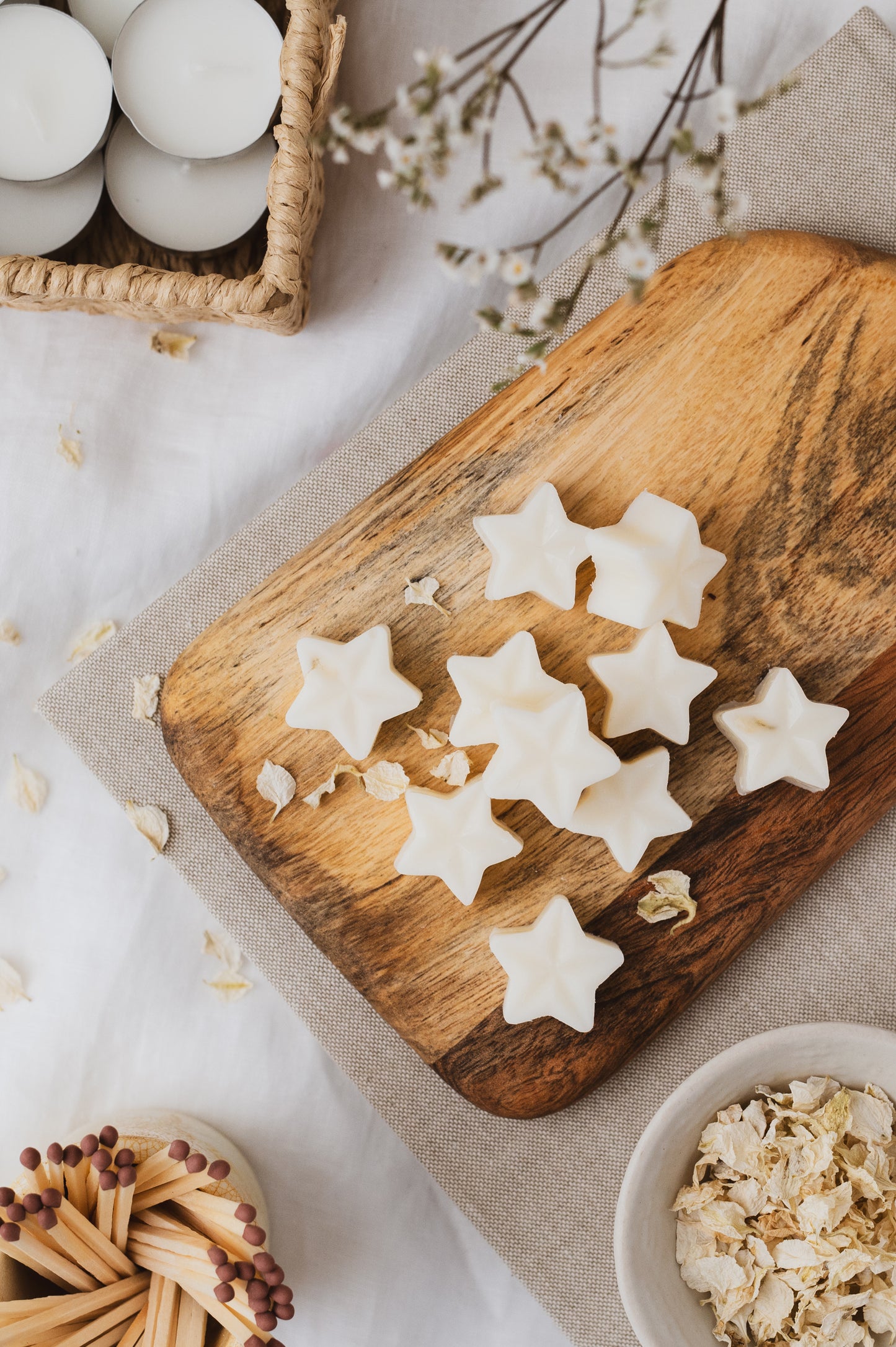 Star-shaped Apple and Cinnamon botanical wax melts resting on a chopping board.