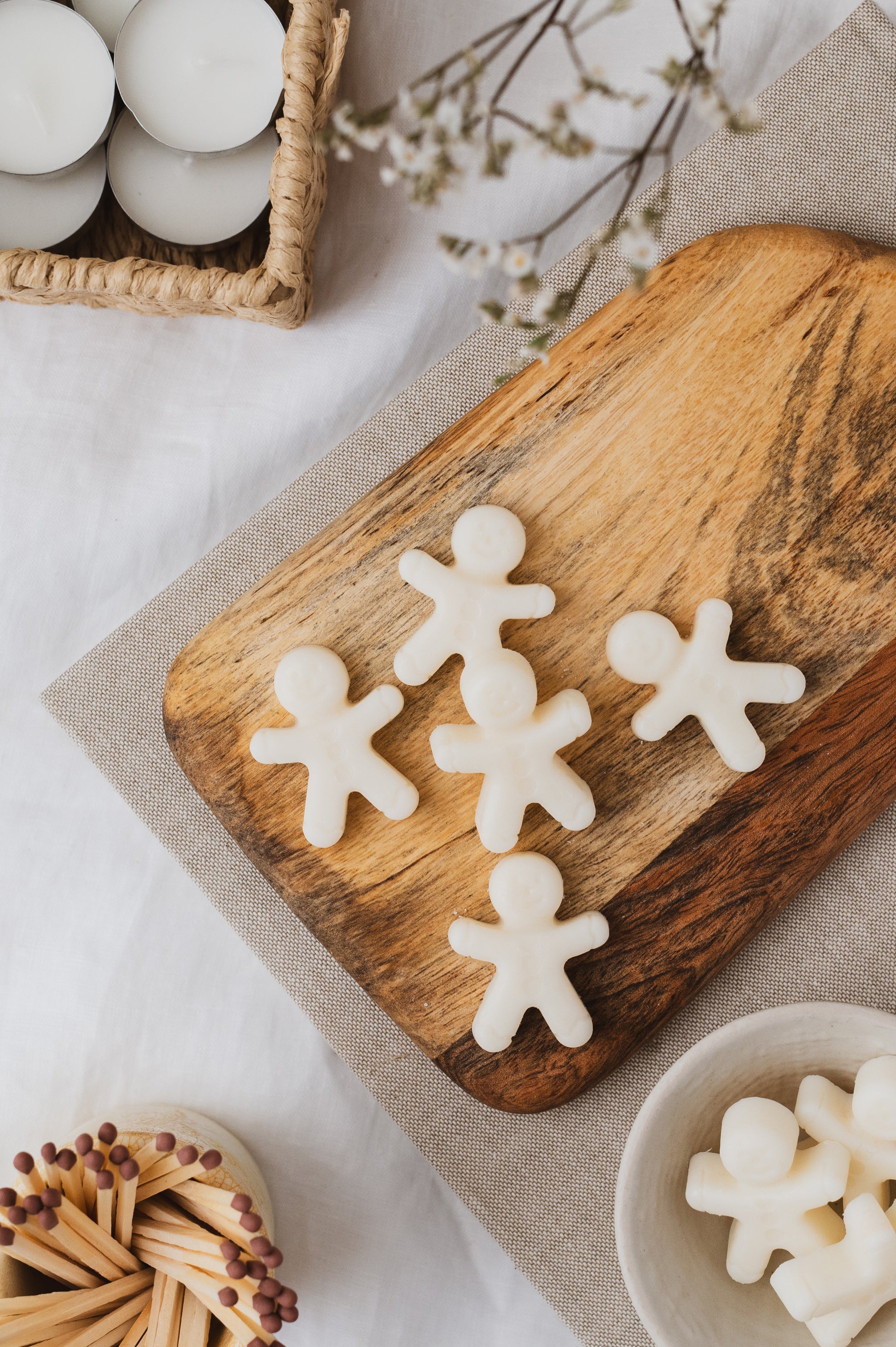 Gingerbread shaped soy wax melts on a chopping board.